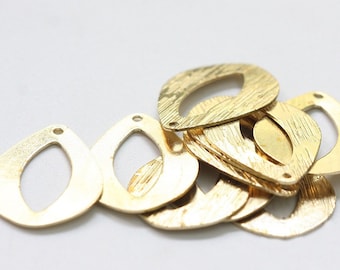 May include: A pile of gold-colored metal teardrop-shaped charms with a hole at the top. The charms have a textured surface.