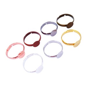 Op de afbeelding: Zes verstelbare ringblanken met ronde metalen bezels in verschillende kleuren, waaronder zilver, goud, brons, koper en rosé goud.