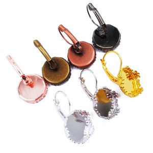May include: Six pairs of earring settings with different finishes. The settings are silver, gold, rose gold, bronze, and black. Each setting has a round bezel with a scalloped edge.
