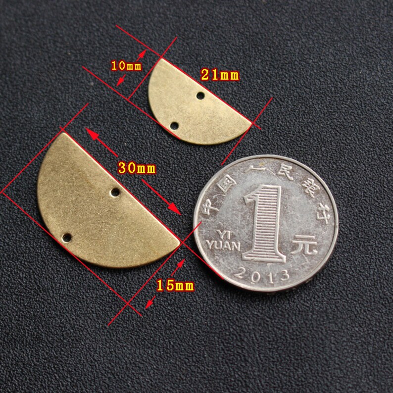 Puede incluir: Dos formas de medio c&iacute;rculo de lat&oacute;n con dos agujeros cada una. La forma m&aacute;s grande mide 30 mm de ancho y 15 mm de alto. La forma m&aacute;s peque&ntilde;a mide 21 mm de ancho y 10 mm de alto. Se incluye una moneda china yuan como referencia de tama&ntilde;o.