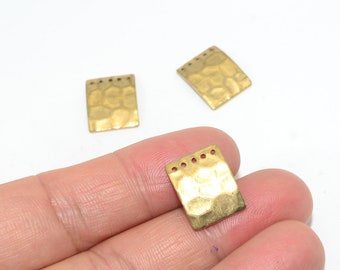 May include: Three gold-toned metal rectangular charms with a hammered texture and small holes along the top edge.