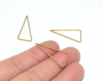 Puede incluir: Tres colgantes triangulares dorados de marco abierto. Uno está sostenido por los dedos de una persona. Los colgantes están hechos de metal fino y están sobre un fondo blanco. Estas formas geométricas son ideales para la fabricación de joyas.
