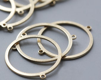 May include: A set of three gold-toned metal hoops with three small loops on each hoop. The hoops are stacked on top of each other.