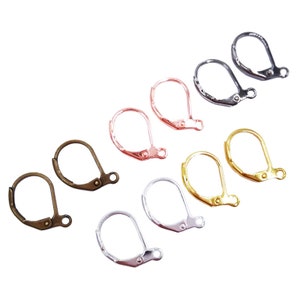 Op de afbeelding: Een set van 10 oorhaken in verschillende afwerkingen, waaronder zilver, goud, rosé goud en antiek messing. De haken zijn gemaakt van metaal en hebben een veerbelaste sluiting.
