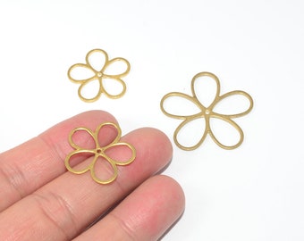 Puede incluir: Tres abalorios de metal dorado en forma de flor con un agujero en el centro. Los abalorios son de diferentes tamaños.