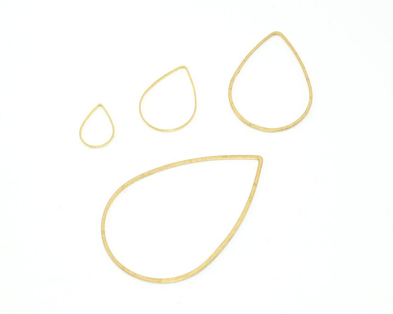 May include: Four gold teardrop-shaped wire hoops of varying sizes. The hoops are on a white background.