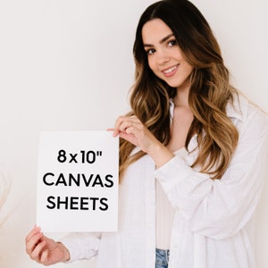 May include: A white card with the text "8x10" Canvas Sheets" held by a person.