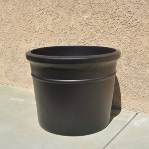 May include: A large, black, round plastic planter pot.