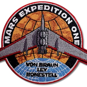 May include: A red, white, and black embroidered patch with the text "Mars Expedition One" around a globe with a stylized spacecraft. The names "Von Braun", "Ley", and "Bonestell" are printed on the globe.