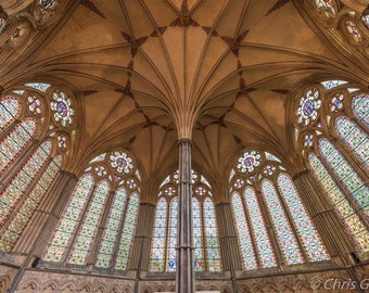 May include: A view of the interior of a cathedral with a vaulted ceiling and stained glass windows. The windows are made up of many small panes of glass, each with a different color and design.
