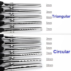 Könnte beinhalten: Ein Set aus Bastelscheren aus Metall mit schwarzen Griffen und verschiedenen Klingenmustern. Der obere Bereich zeigt dreieckige Zähne in den Größen 2mm, 3mm, 4mm, 5mm und 7mm. Der untere Bereich zeigt kreisförmige Zähne in 3mm, 4mm, 5mm, 7mm, 10mm und 18mm.