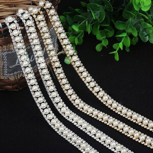May include: Three strands of trim featuring a double row of faux pearls and a row of clear rhinestones.