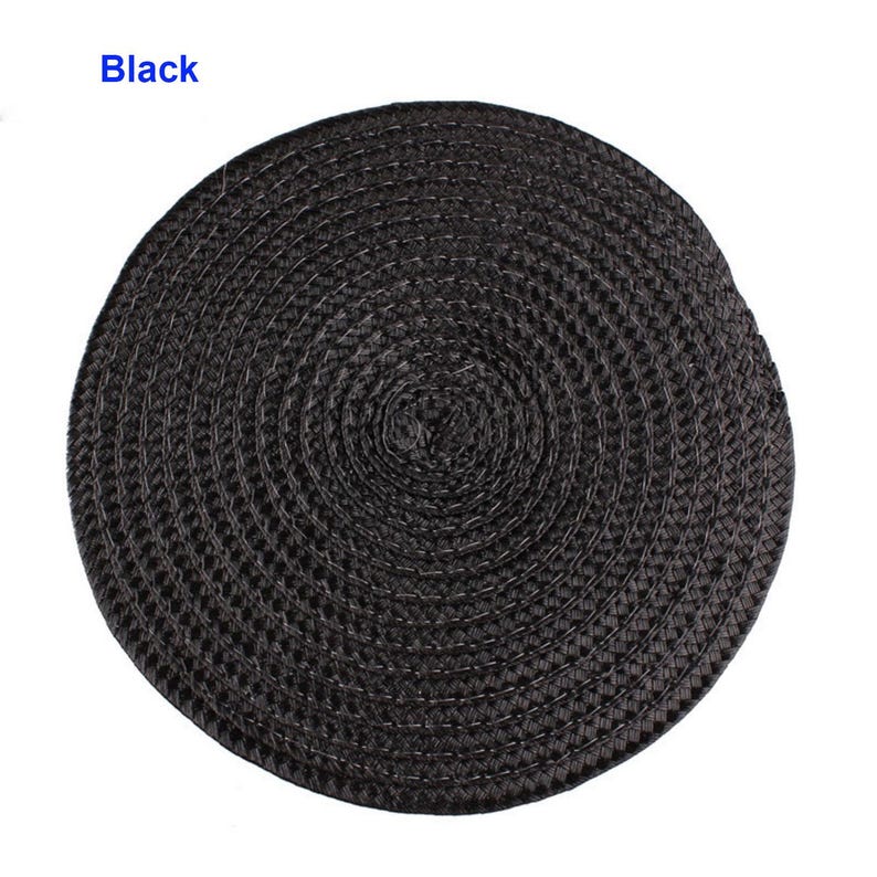 May include: A round, black woven placemat. The placemat is made of a tightly woven material, creating a textured surface. The word "Black" is printed in the upper left corner.