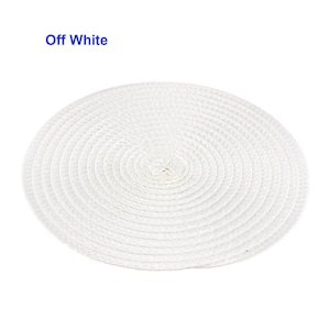 May include: Off-white, round woven placemat. The placemat is made of a natural fiber and has a spiral design. The text "Off White" is in the upper left corner.