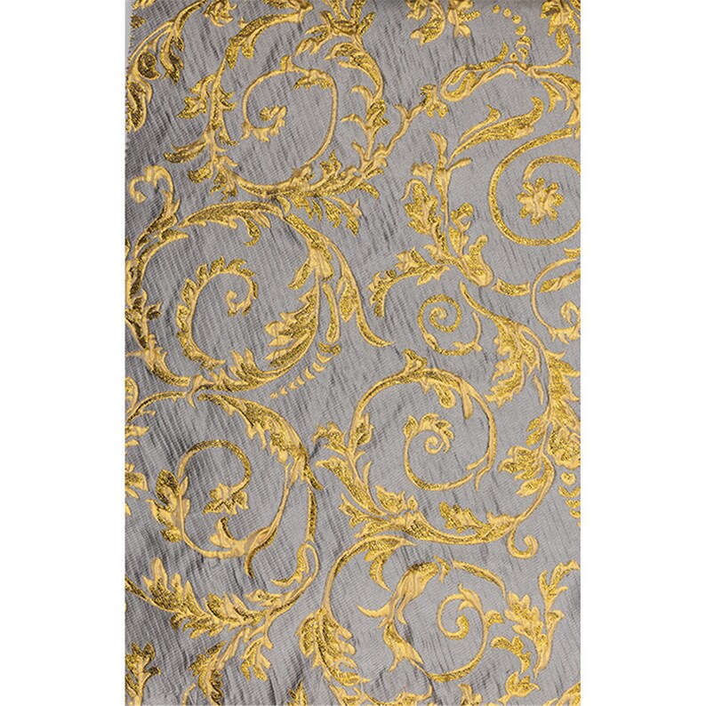 May include: A gray fabric with a gold floral pattern. The pattern is a repeating design of swirling leaves and vines.