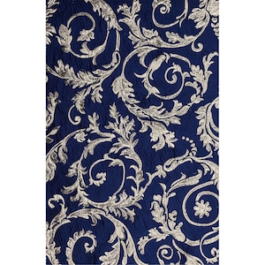 May include: A navy blue fabric with a silver floral pattern. The pattern is a repeating design of leaves and swirls.