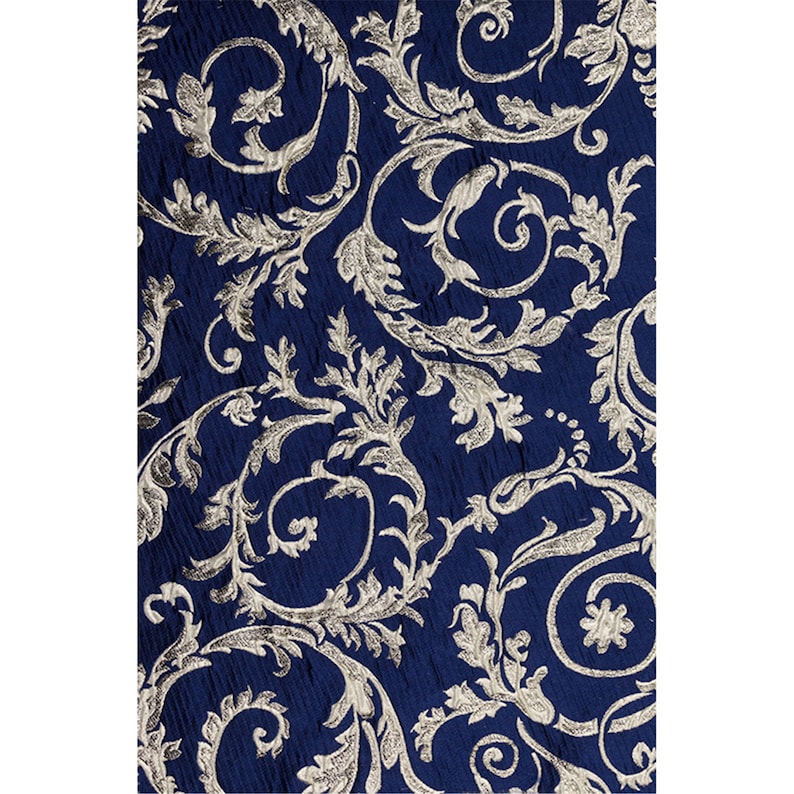 May include: A navy blue fabric with a silver floral pattern. The pattern is a repeating design of leaves and swirls.