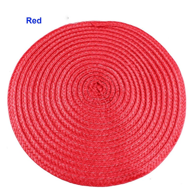 May include: A round, red placemat with a woven design. The placemat is circular and made of a tightly woven material. The word "Red" is in the upper left corner. This placemat is suitable for dining and kitchen decor.