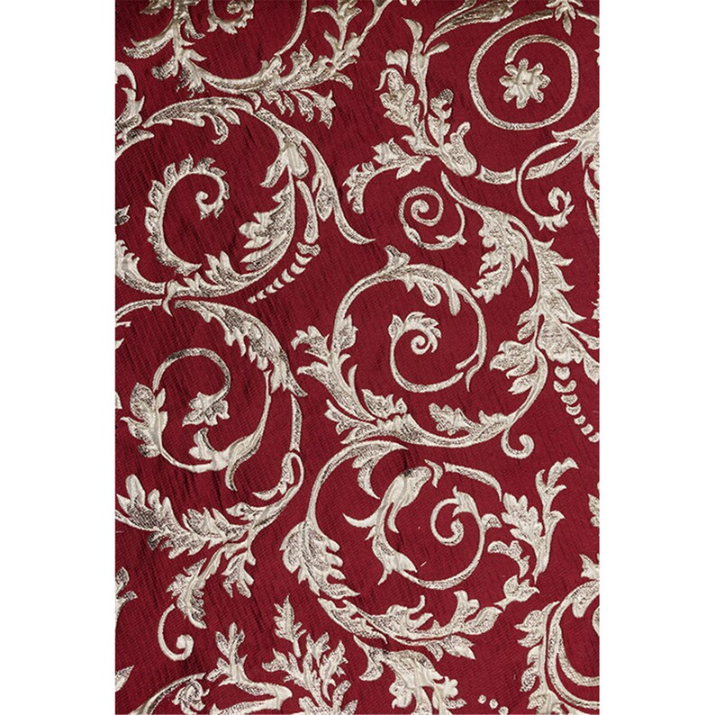 May include: Red fabric with a gold damask pattern. The pattern features swirling vines and leaves.
