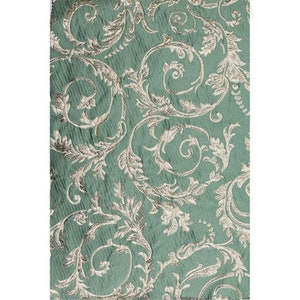 May include: Teal fabric with a silver metallic floral pattern. The fabric has a textured, woven look.