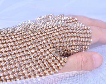 May include: A gold mesh glove with clear rhinestones covering the entire surface.