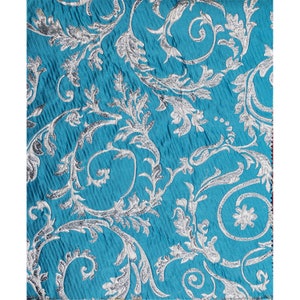 May include: Teal fabric with a silver floral pattern. The fabric has a textured, woven look.