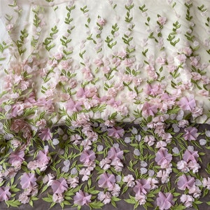 May include: Pink and green floral embroidered fabric with 3D flowers. The fabric has a delicate, sheer texture.