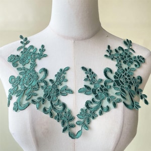 Puede incluir: Una aplicación de encaje floral verde con un diseño delicado. El encaje está hecho de una tela suave y transparente y presenta intrincados patrones florales. Esta aplicación es perfecta para agregar un toque de elegancia a cualquier proyecto.