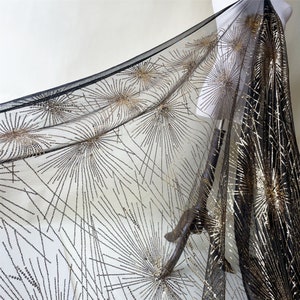 May include: Black and gold sequined fabric with a geometric pattern of radiating lines. The fabric has a sheer, mesh-like texture.