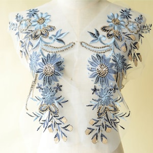 May include: Blue and gold floral applique with beaded embellishments. The applique is on a sheer mesh fabric.