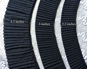 May include: Three black fabric trims with different widths, 4.3 inches, 3 inches, and 2.2 inches. The trims are pleated and have a wavy edge.