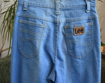 Puede incluir: Un par de pantalones vaqueros de color azul claro con una etiqueta de cuero marrón Lee en el bolsillo trasero.