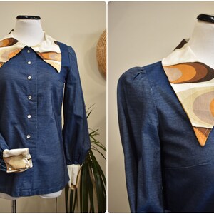 May include: A blue denim shirt with a large, white, brown, and orange patterned collar. The collar has a geometric design.