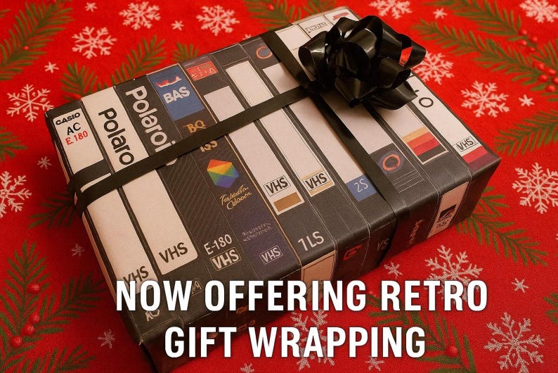 A gift wrapped in a black ribbon with a bow, featuring a collection of VHS tapes on the wrapping paper.