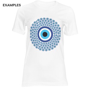 May include: A white short-sleeved t-shirt featuring a large, circular graphic on the chest. The design consists of a central black, light blue, and dark blue eye symbol surrounded by a dense pattern of numerous smaller blue and white eye motifs.