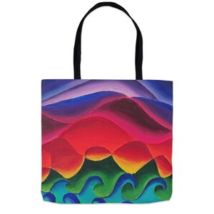 May include: A tote bag featuring a vibrant, abstract landscape painting. The design displays layered, undulating hills in shades of purple, red, and orange, transitioning into stylized, rolling ocean waves in blue and green at the bottom.