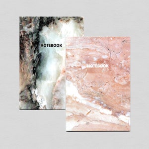 Puede incluir: Dos cuadernos con tapas de mármol. El cuaderno de la izquierda tiene una tapa de mármol verde y blanco con la palabra "NOTEBOOK" impresa en negro. El cuaderno de la derecha tiene una tapa de mármol rosa y blanco con la palabra "NOTEBOOK" impresa en blanco.