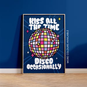 May include: A framed print with a navy blue background features a colorful disco ball illustration. The text "KISS ALL THE TIME" and "DISCO OCCASIONALLY" are in white. The words "MORE COLOURS AVAILABLE" are printed vertically on the right side.