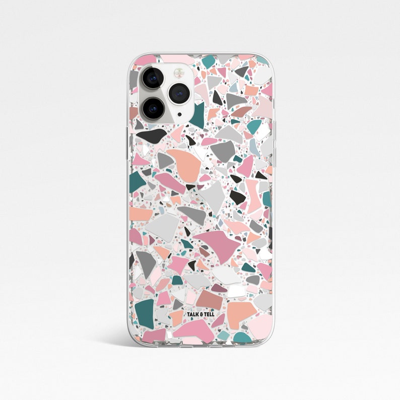 K&ouml;nnte beinhalten: Transparente Handyh&uuml;lle mit Terrazzo-Muster. Das Design zeigt unregelm&auml;&szlig;ige Formen in Rosa, Pfirsich, T&uuml;rkis, Grau und Schwarz auf wei&szlig;em Hintergrund. Der Text "TALK & TELL" ist unten auf der H&uuml;lle aufgedruckt.