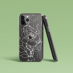 May include: A clear phone case featuring a white design of a snake coiled around a rose. The design also includes stars and a crescent moon. The text "Talk & Tell" is at the bottom of the design.
