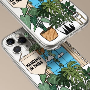 May include: A clear phone case with a white background and a design of hanging plants in pots. The text "Hanging in there" is on a white banner. The case has a blue window with white clouds and a black and white pot with the text "Talk & Tell".