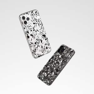 May include: Two clear phone cases with a black and white terrazzo pattern. The cases are designed for an iPhone with a camera bump.