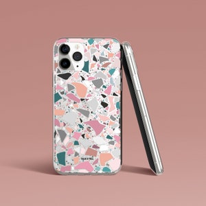 K&ouml;nnte beinhalten: Transparente Handyh&uuml;lle mit Terrazzo-Muster in Rosa, T&uuml;rkis, Grau und Pfirsich. Sie lehnt an einem silbernen Smartphone. Der Text "TALK & TELL" ist unten auf der H&uuml;lle zu sehen.