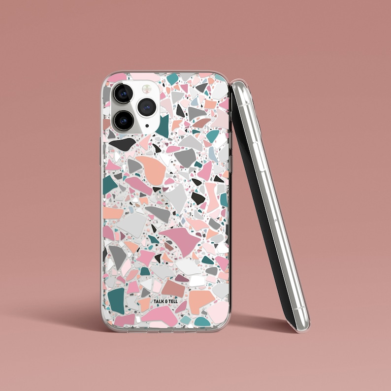 K&ouml;nnte beinhalten: Transparente Handyh&uuml;lle mit Terrazzo-Muster in Rosa, T&uuml;rkis, Grau und Pfirsich. Sie lehnt an einem silbernen Smartphone. Der Text "TALK & TELL" ist unten auf der H&uuml;lle zu sehen.