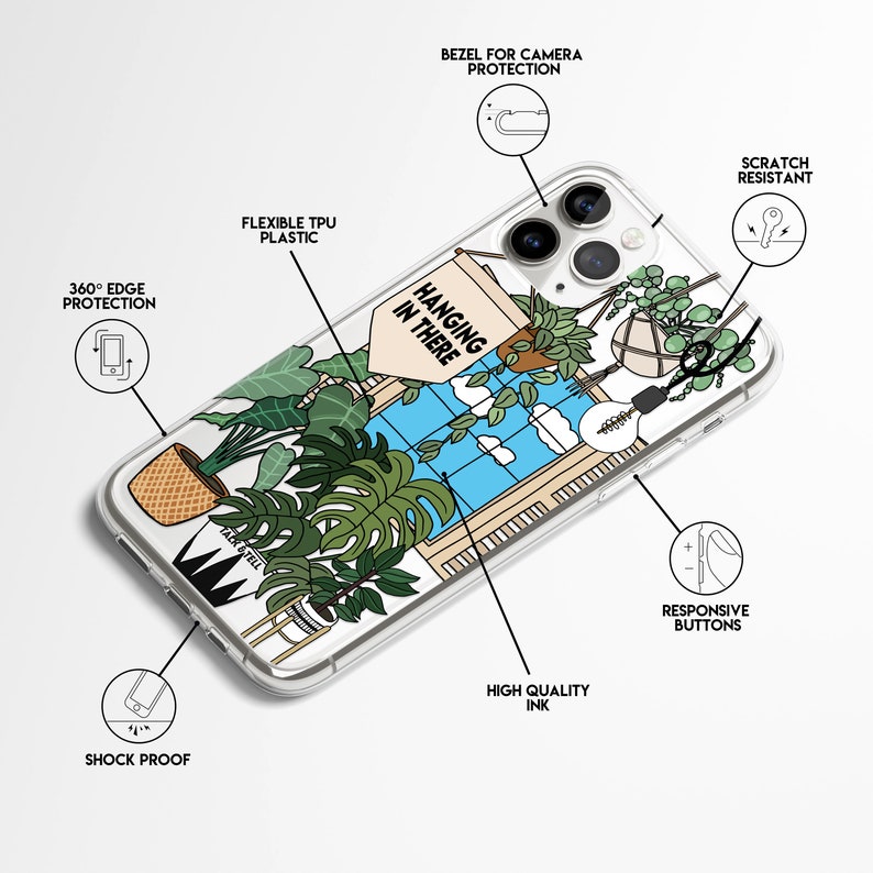 May include: A clear phone case featuring a design of a window with plants hanging from it. The text "HANGING IN THERE" is on a sign hanging from the window. The case has a raised bezel around the camera lens for protection.