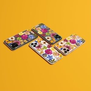 Może przedstawiać: Cztery etui na iPhone z kwiatowymi wzorami. Każde etui prezentuje inny układ prasowanych kwiat&oacute;w w odcieniach r&oacute;żowego, ż&oacute;łtego, białego i zielonego.