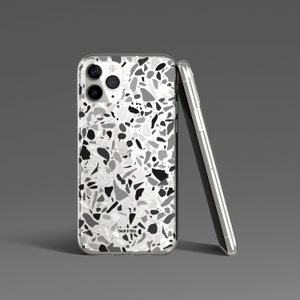 May include: A clear phone case with a black, white, and gray terrazzo pattern. The case has a "Talk & Tell" logo on the back.