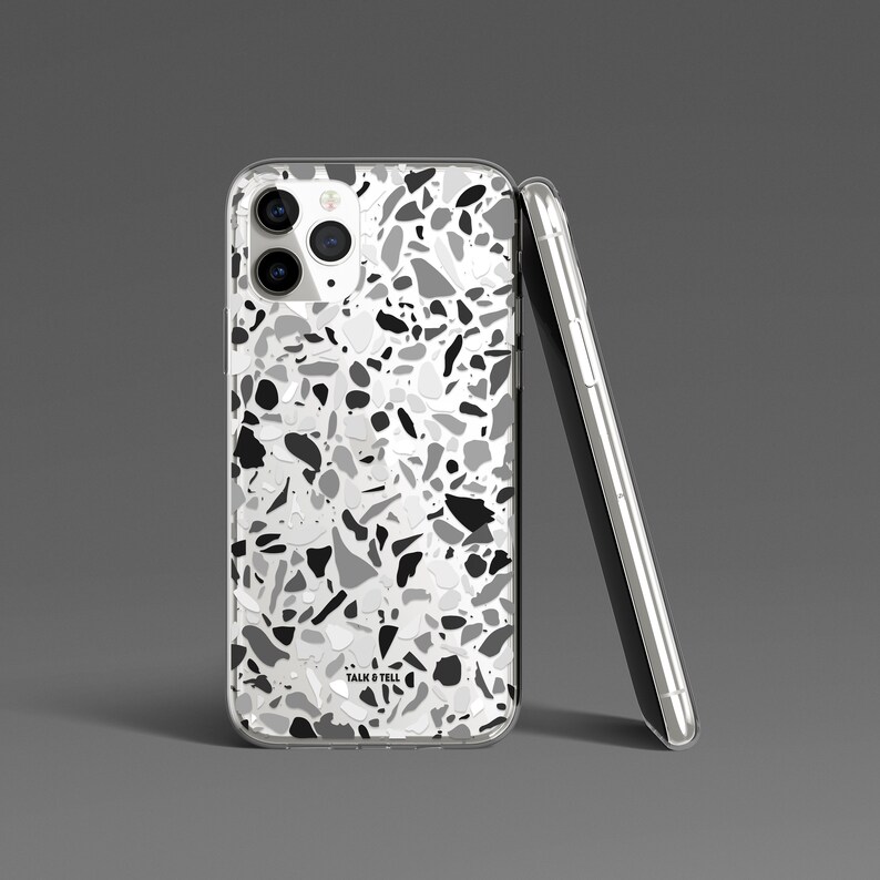 May include: A clear phone case with a black, white, and gray terrazzo pattern. The case has a "Talk & Tell" logo on the back.