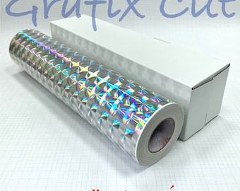 Pode incluir: Um rolo de vinil mosaico holográfico prateado de 1,5" com um núcleo branco. O vinil está em uma caixa branca com o texto "Grafix Cut" impresso nele.