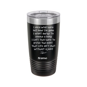 May include: A black stainless steel tumbler with a white inscription that reads "I once was here but now I'm gone I went away to smoke a bong I left this here to prove the point that life ain't shit without a joint". The tumbler has a silver lid and the word "Name" is at the bottom of the inscription.